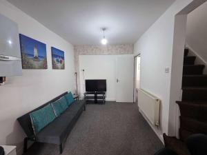 a living room with a couch and a television at Inviting 3-Bed Home in Worksop with Street Parking in Creswell +27 photos