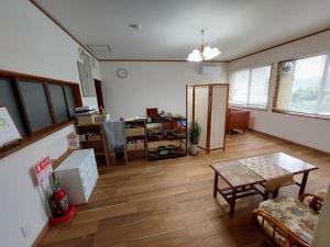 a large living room with a table and a room with at ゲストハウス凪季のやど in Nachikatsuura
