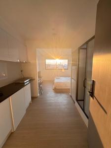 MetaWise Cozy Retreat close to Monash Uni and Chadstone U3 في Oakleigh South: غرفة صغيرة بها سرير ومطبخ +13 صورة