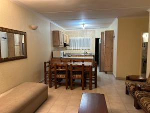 a kitchen and living room with a table and chairs at Eden Wilds 42 in Port Edward