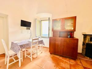 ein Esszimmer mit Tisch und Stühlen und einem Kamin in der Unterkunft Dimora Concept - Casa Saracena - Sea View, Terrace and Free Parking in Ranzi