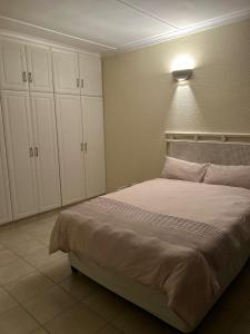 a bedroom with a large bed with white cabinets at Eden Wilds 42 in Port Edward +20 photos
