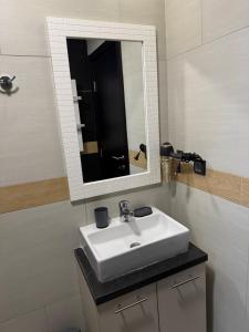 a bathroom with a white sink and a mirror at Apartmani Glamur Kopaonik in Kopaonik +70 photos