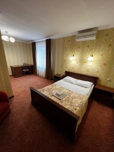 a hotel room with a large bed and a table at Zolotoy Fazan in Mykolaiv