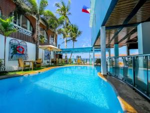 a swimming pool in front of a building at Montani Beach Resort Puerto Galera powered by Cocotel in Puerto Galera