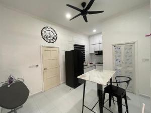 a kitchen with a black refrigerator and a clock on the wall at Qaseh homestay in Kota Bharu +5 photos