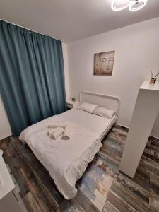 a bedroom with a bed with a green curtain at Petit Blue in Dudu