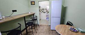 a kitchen with a counter and a refrigerator and a table at Koktem hostel in Aktobe