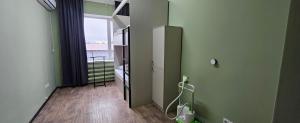a bathroom with green walls and a door with a window at Koktem hostel in Aktobe