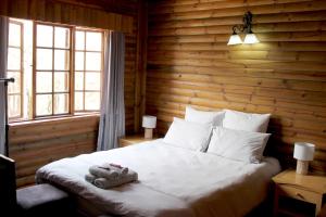 Un dormitorio con una cama con un animal de peluche encima. en River Ridge Log Home - Inside Dinokeng Big 5, en Klipdrift