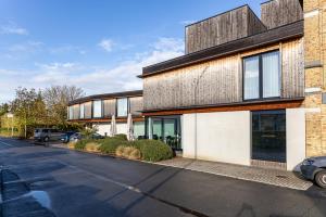 a building with a car parked in front of it at Hotel Bell-X Kortrijk-Wevelgem in Wevelgem