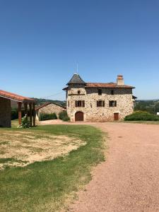 Un antiguo edificio de piedra con un camino delante de él. en Le gîte de caractère, en Flagnac