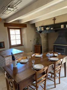 comedor con mesa de madera y chimenea en Le gîte de caractère, en Flagnac