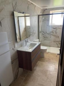 Un baño con lavabo, inodoro y espejo. en Le gîte de caractère, en Flagnac