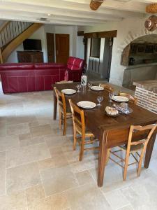 Una mesa y sillas de madera en una sala de estar. en Le gîte de caractère, en Flagnac