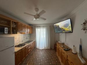 a kitchen with a flat screen tv on the wall at House with balcony and views of the Atlantic in El Pris in El Pris +19 photos