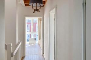 einen Flur mit weißen Wänden und einem Kronleuchter in der Unterkunft NordseeResort Friesland NordseeResort Friesland 1 in Schillig