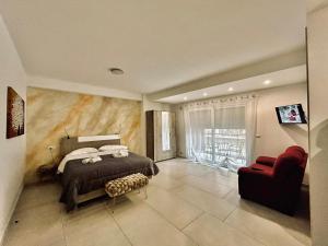 Un dormitorio con una cama y una silla roja. en Aqua Marine B&B - Rooms and Apartments, en Milazzo
