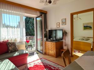 a living room with a couch and a television at Garden Apartments Janša in Radovljica +58 photos