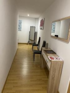 a room with a desk and chairs and a mirror at Apartamento Fuente del Genil. in Fuente Vaqueros +13 photos
