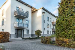 a row of white apartment buildings with balconies at Nahe Airport Ber Adlershof in Schönefeld