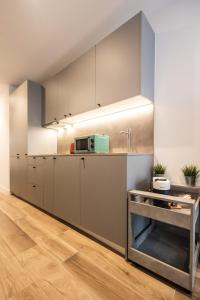 una cucina con mobili bianchi e un forno a microonde di Cielo y Mar a Valencia Altre 14 foto