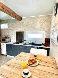 a kitchen with a table with a plate of pastries on it at Le Chant des Oiseaux-Campagne-SPA-Parking in Abbeville