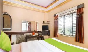 a bedroom with a bed and a desk and a television at FabHotel Rose in kolkata