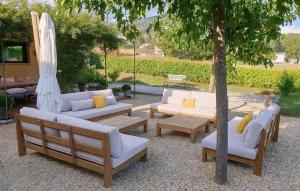 a group of couches and a umbrella and a tree at Maison Avec Piscine in La Roque-Esclapon +27 photos
