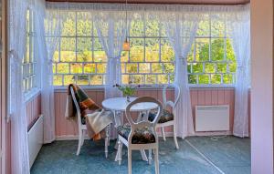 a table and chairs in a room with a window at Beautiful Home In Vistdal With Wifi in Myklebostad