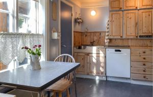 a kitchen with a table with a vase of flowers on it at Beautiful Home In Vistdal With Wifi in Myklebostad
