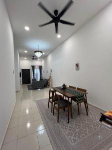 a dining room with a table and a ceiling fan at Hasya Guesthouse in Seri Iskandar