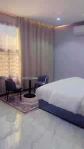 een slaapkamer met een bed, een tafel en stoelen bij شقق الفايز in Al Ula +12 foto's