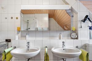 a bathroom with two sinks and a mirror at Ferienwohnung Lilly in Schwanau +28 photos