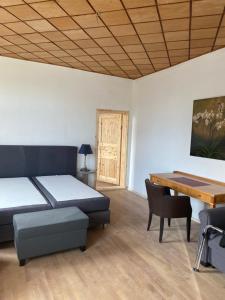 a room with a bed and a desk and a table at Gutshaus Kletzin mit Pool und Minigolf-Anlage in Siedenbrünzow