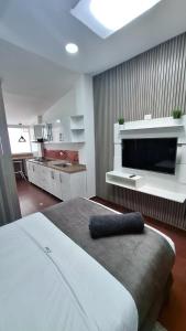 ボゴタにあるHotel Boutique CGH Aeropuertoのベッドルーム(大型ベッド1台、大画面テレビ付)