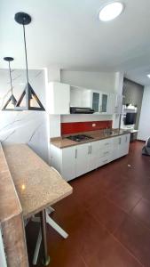 a large kitchen with white cabinets and a table at Hotel Boutique CGH Aeropuerto in Bogotá +28 photos