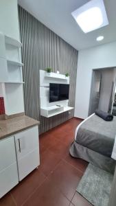 ボゴタにあるHotel Boutique CGH Aeropuertoのベッドと薄型テレビのある寝室