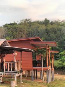 a small red house with a porch and a deck at Baan Seaview Sunset in Phra Ae beach
