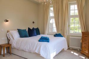 a bedroom with a bed with blue pillows on it at The Dower House at Solsgirth Home Farm in Dollar