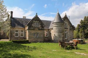 an old stone house with a table in front of it at The Dower House at Solsgirth Home Farm in Dollar