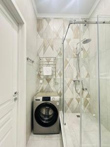 uma máquina de lavar roupa na casa de banho com um chuveiro em GRAND-TURAN Bussiness em Astana