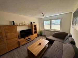 a living room with a couch and a television at Schöne Gästewohnung zum Erholen in Bad Sülze