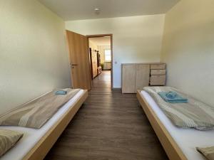two beds in a room with a hallway at Schöne Gästewohnung zum Erholen in Bad Sülze