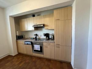 a kitchen with wooden cabinets and a stove top oven at Schöne Gästewohnung zum Erholen in Bad Sülze