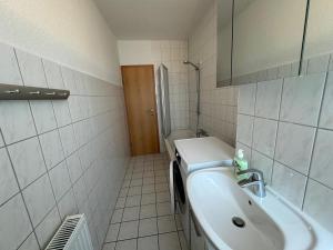 a bathroom with a sink and a mirror and a tub at Schöne Gästewohnung zum Erholen in Bad Sülze