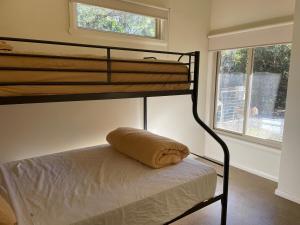 a bunk bed with a pillow on the bottom bunk at One Mile Bridge - Off Grid Stays in Mole Creek