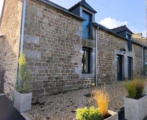 ein Backsteingebäude mit zwei Topfpflanzen davor in der Unterkunft Ker Loal 