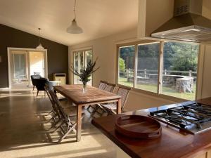 a kitchen and dining room with a table and a stove at One Mile Bridge - Off Grid Stays in Mole Creek