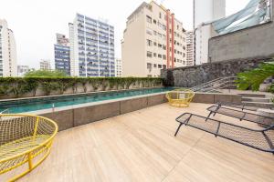 - un balcon avec des chaises et une piscine dans un bâtiment dans l'établissement B Homy Genebra, à São Paulo